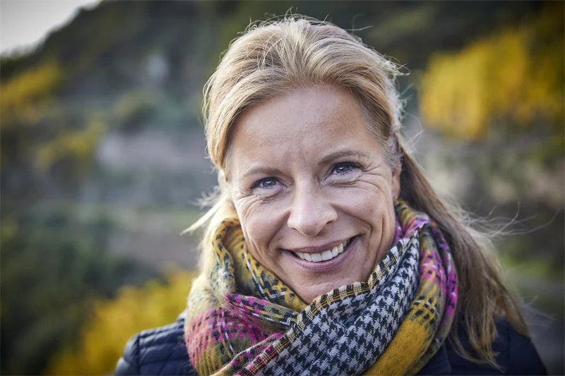 Kvinna med lyster i sin hud som står utomhus